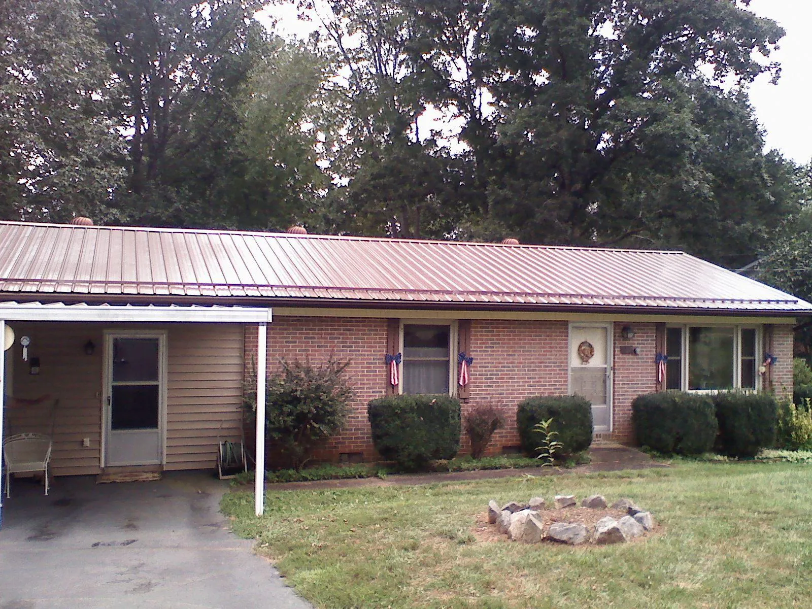 Bronze metal roof and carport on a brick ranch home — Roof Repair work by our crew in Ferris